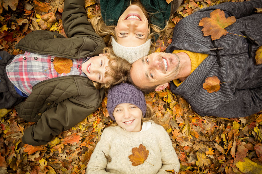 46685110 - smiling young family doing a head circles on an autumns day